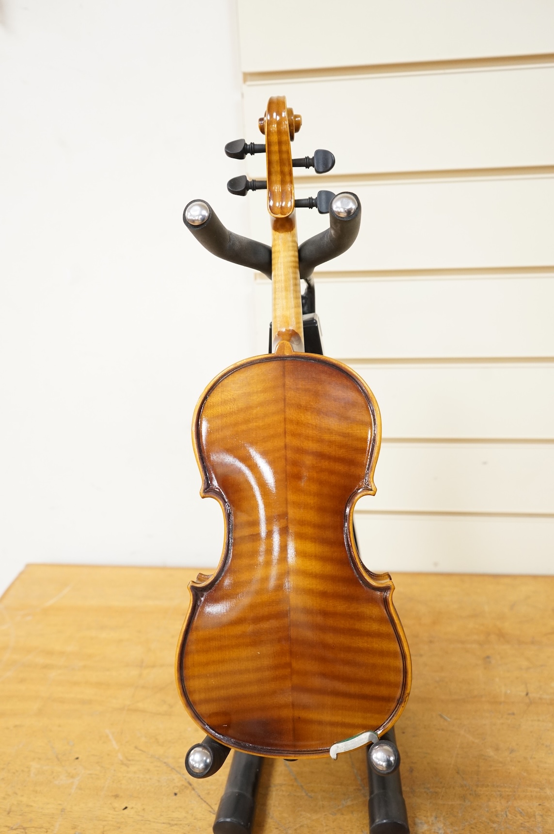 Five cased 20th century violins, including; a German violin, two Czech violins, a three-quarter size violin with a label for Bienfait, and a Romanian quarter size violin, all in cases or the remains of cases.